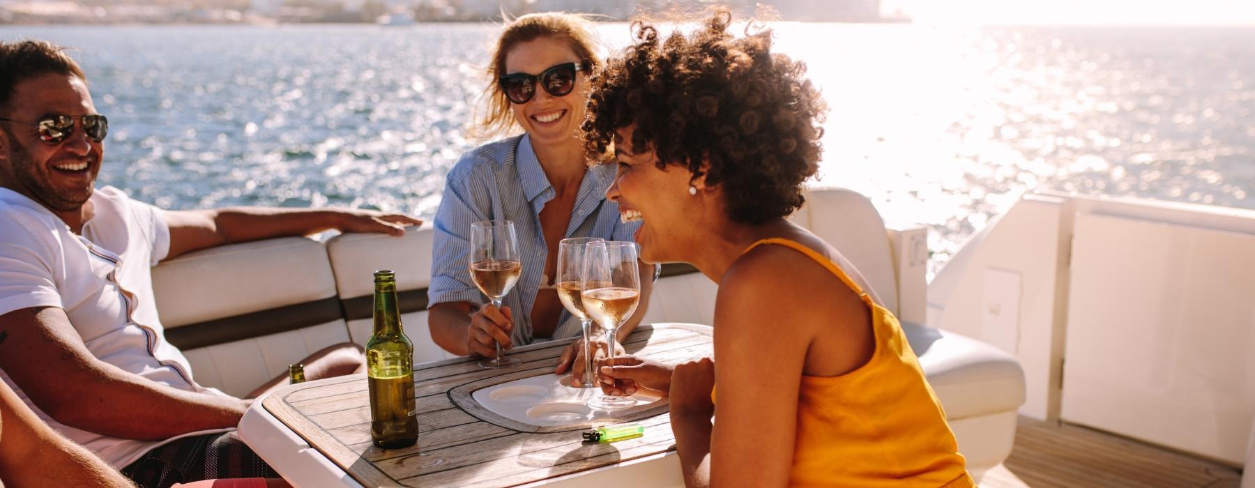 a group of people sitting at a table with drinks on a boat