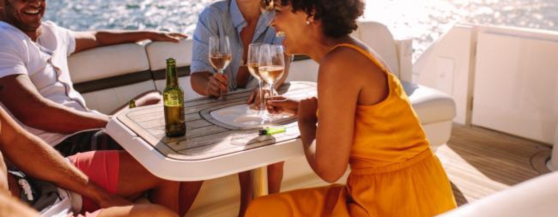 a group of people sitting at a table with drinks on a boat