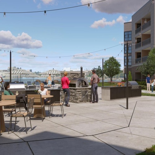State-of-the-art amenities people sitting at tables outside by the community grill